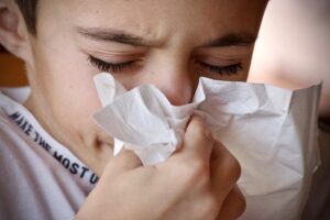 A young boy sneezing in a home in Harrisburg because of allergies